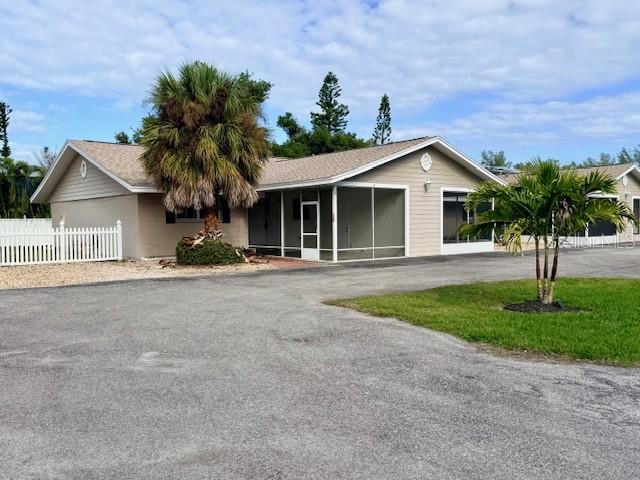A single-story house with a screened-in porch and a large palm tree in the front — 420 FIREHOUSE COURT UNIT 10, LONGBOAT KEY, FL