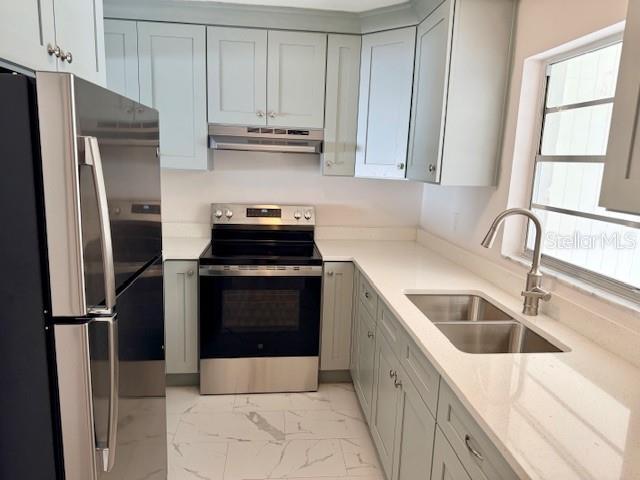A kitchen features light blue cabinets, stainless steel appliances, white countertops, and white tile flooring — 420 FIREHOUSE COURT UNIT 10, LONGBOAT KEY, FL