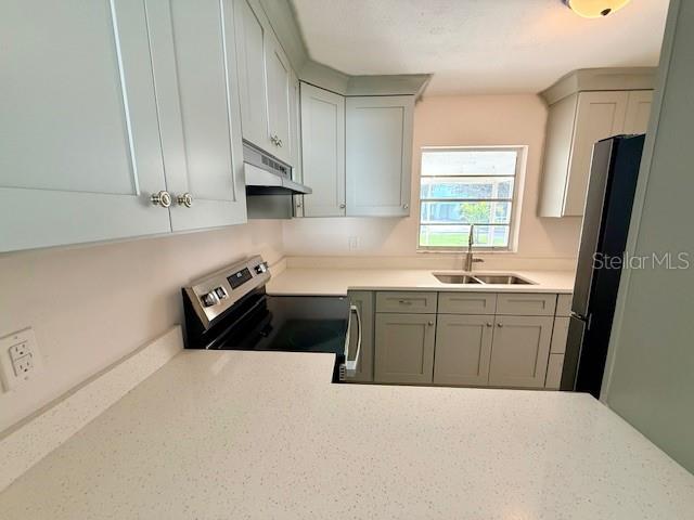 A kitchen features light gray cabinets, white speckled countertops, and stainless steel appliances — 420 FIREHOUSE COURT UNIT 10, LONGBOAT KEY, FL