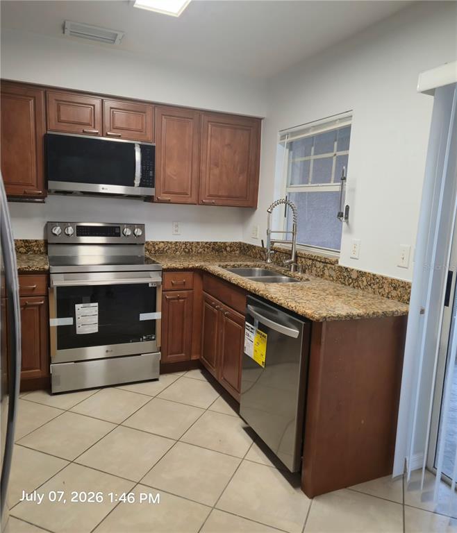 An aerial view of a residential townhouse community featuring multiple buildings, parking lots, and ponds — 734 KENSINGTON LAKE CIR UNIT BRANDON, BRANDON, FL
