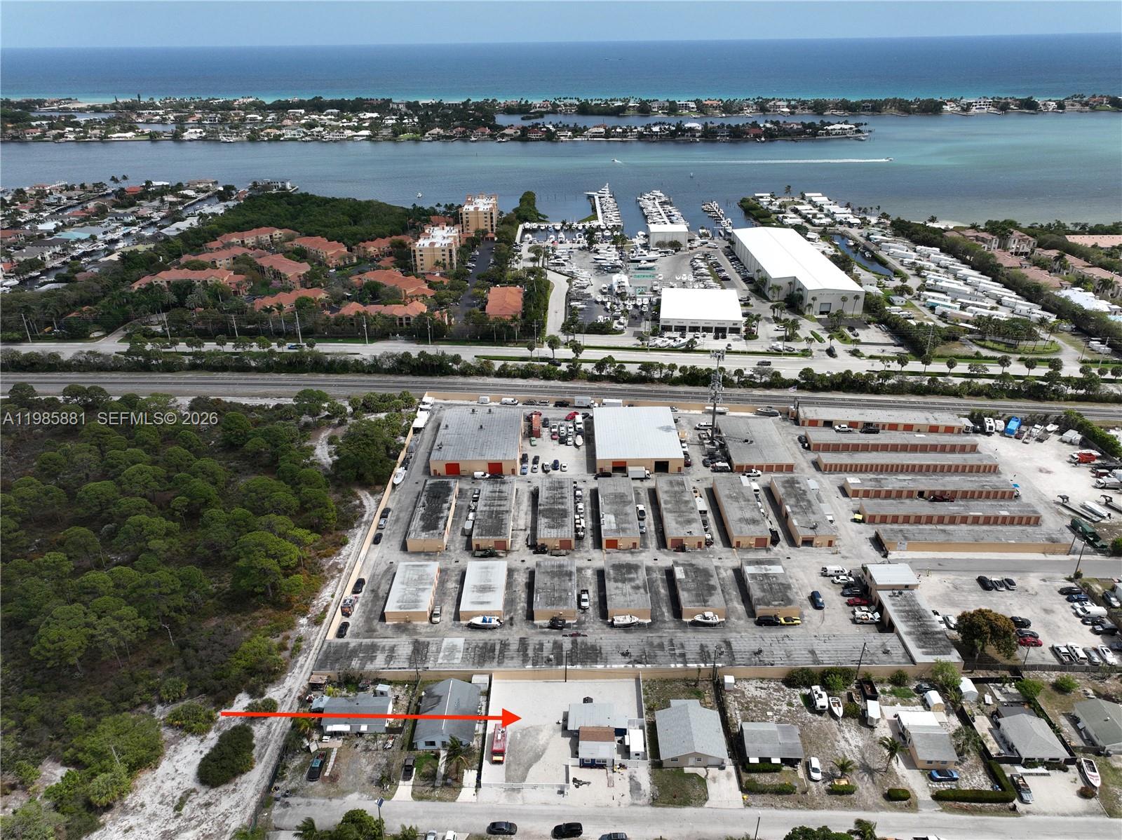 An aerial view shows a storage facility complex with adjacent houses and a nearby marina — 7772 Loomis St, Hypoluxo FL 33462, HYPOLUXO, FL