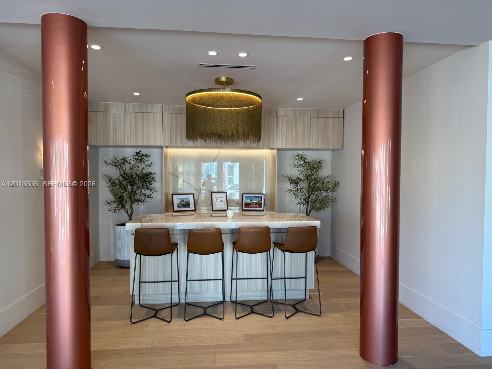 A modern bar area features four leather stools, a marble countertop, and a gold chandelier — 7320 Biscayne Blvd, Miami FL 33138, MIAMI, FL