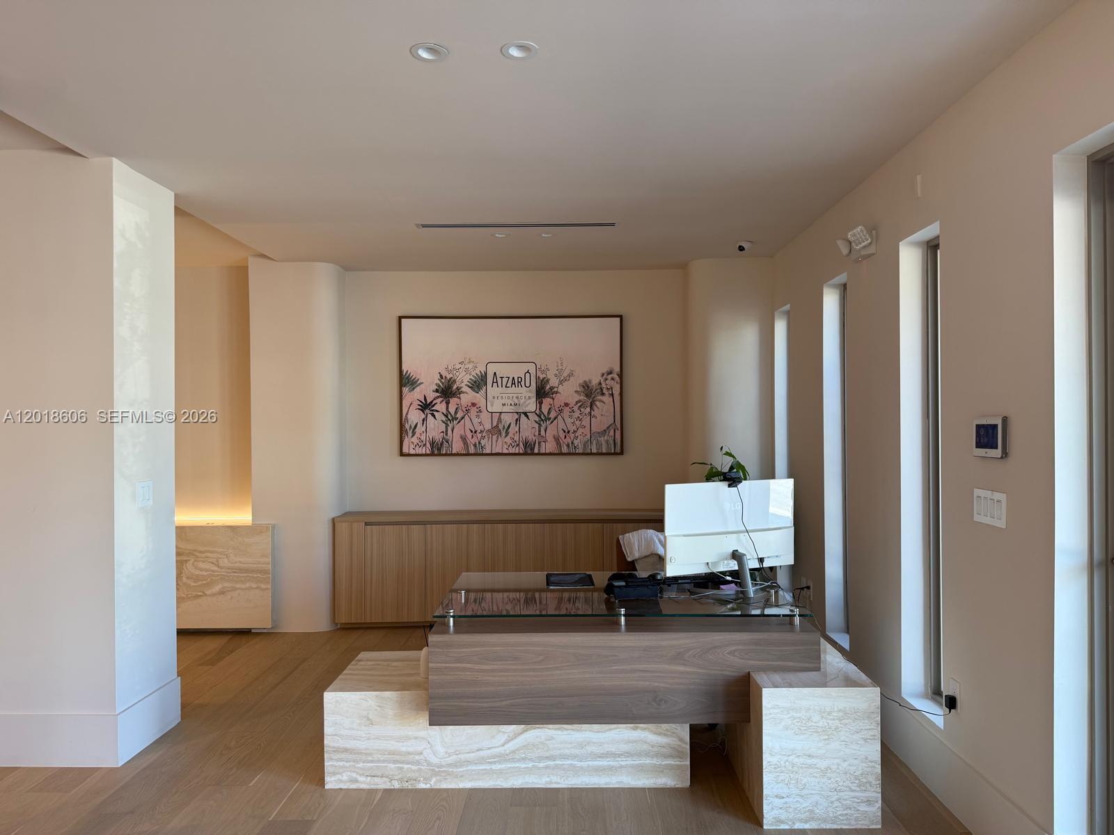 A modern office reception area features a stone and wood desk, artwork, and light-colored walls — 7320 Biscayne Blvd, Miami FL 33138, MIAMI, FL