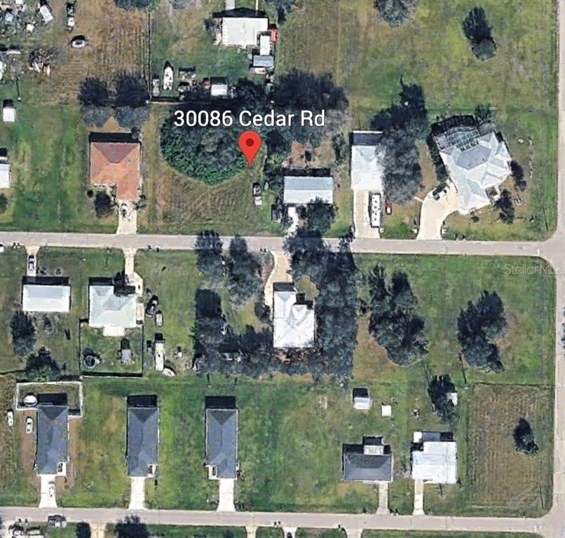 This is an aerial map view showing a residential lot with trees and surrounding houses — 30086 CEDAR ROAD, PUNTA GORDA, FL