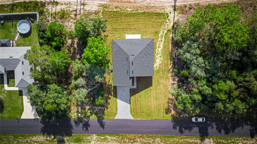 An aerial view shows a house with a gray roof situated on a wooded lot — 6216 SW 155TH STREET ROAD, OCALA, FL