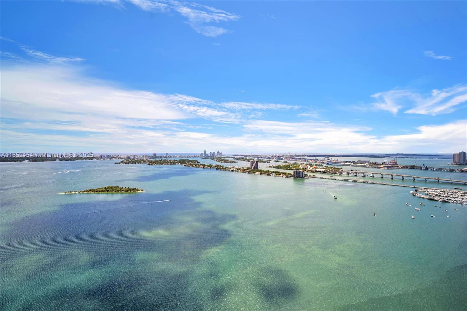 An aerial view shows a bay with islands, a bridge, and a distant city skyline — 700 Ne 24th St # 4507, Miami FL 33137, MIAMI, FL