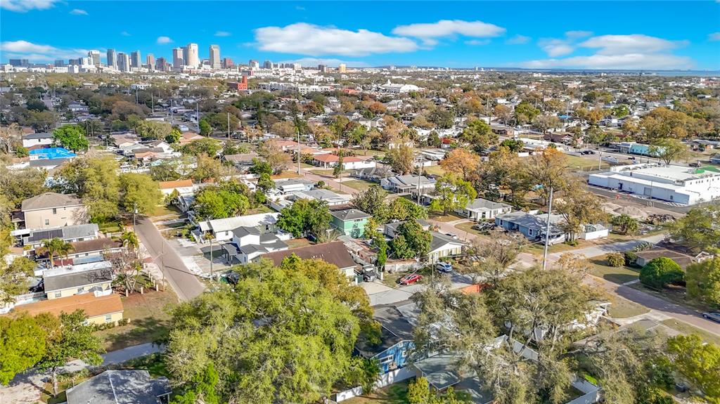 An aerial view shows a residential neighborhood with houses and trees under a blue sky — 3002 W ARCH STREET, TAMPA, FL