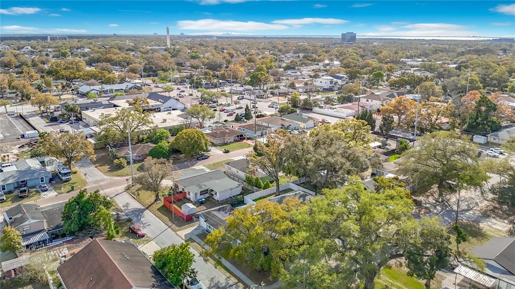 An aerial view shows a suburban neighborhood with houses, trees, and streets under a sky — 3002 W ARCH STREET, TAMPA, FL