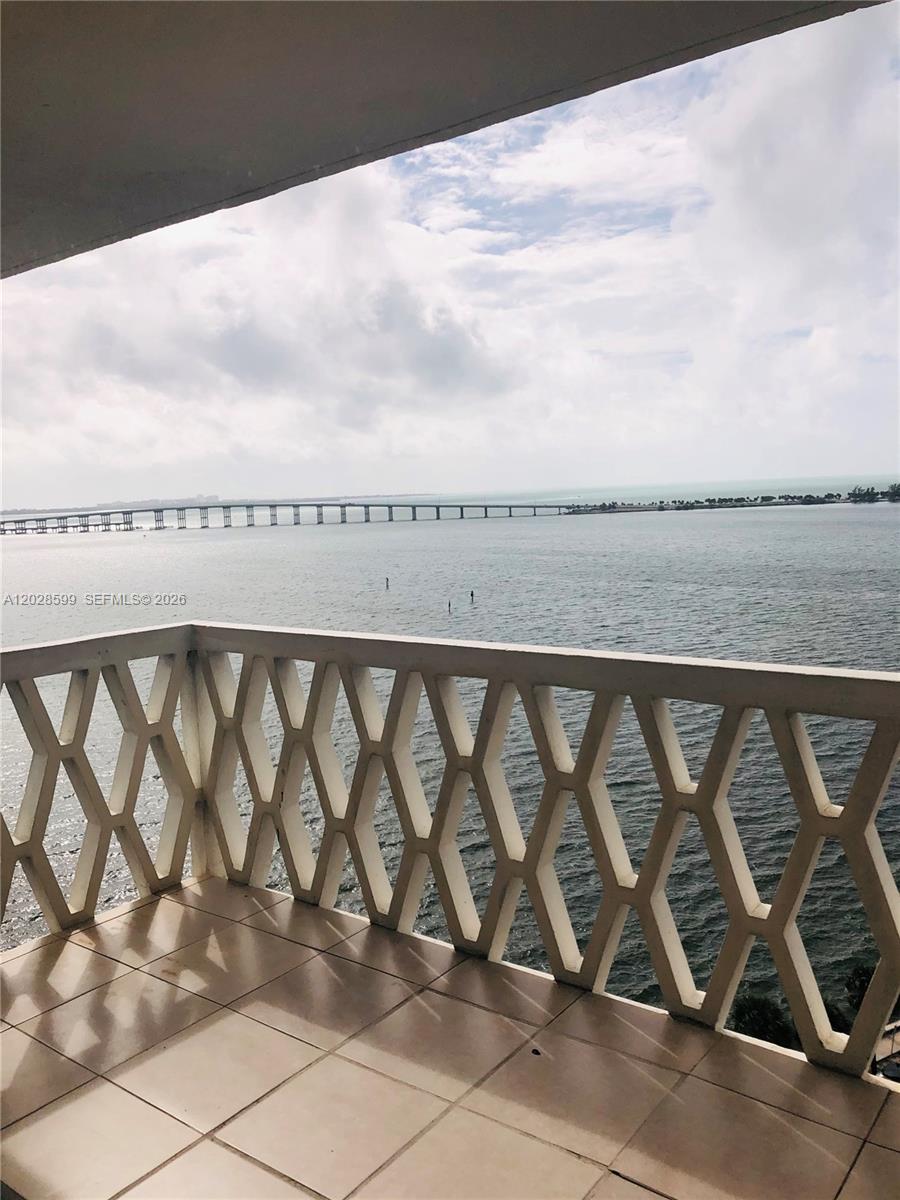 A balcony with a geometric railing overlooks a large body of water and a bridge — 1430 Brickell Bay Dr # 5, Miami FL 33131, MIAMI, FL