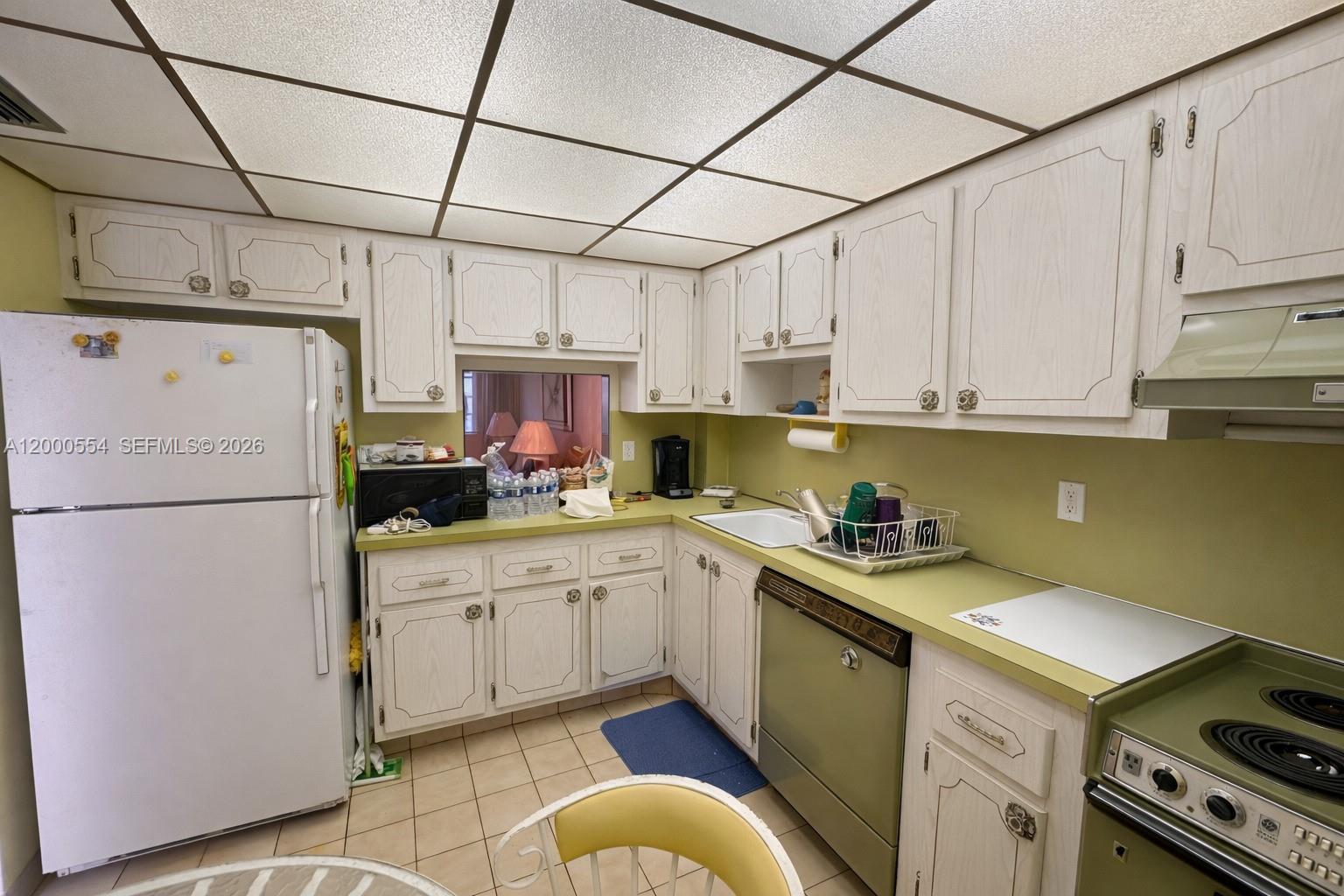 A kitchen features white cabinets, green countertops, a drop ceiling, and a white refrigerator — 410 SE 2nd St # 305, Hallandale Beach FL 33009, HALLANDALE BEACH, FL