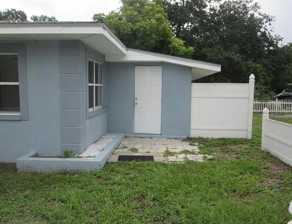 A blue house exterior features a white door, a small patio, and a white fence — 5901 28TH STREET N, ST PETERSBURG, FL