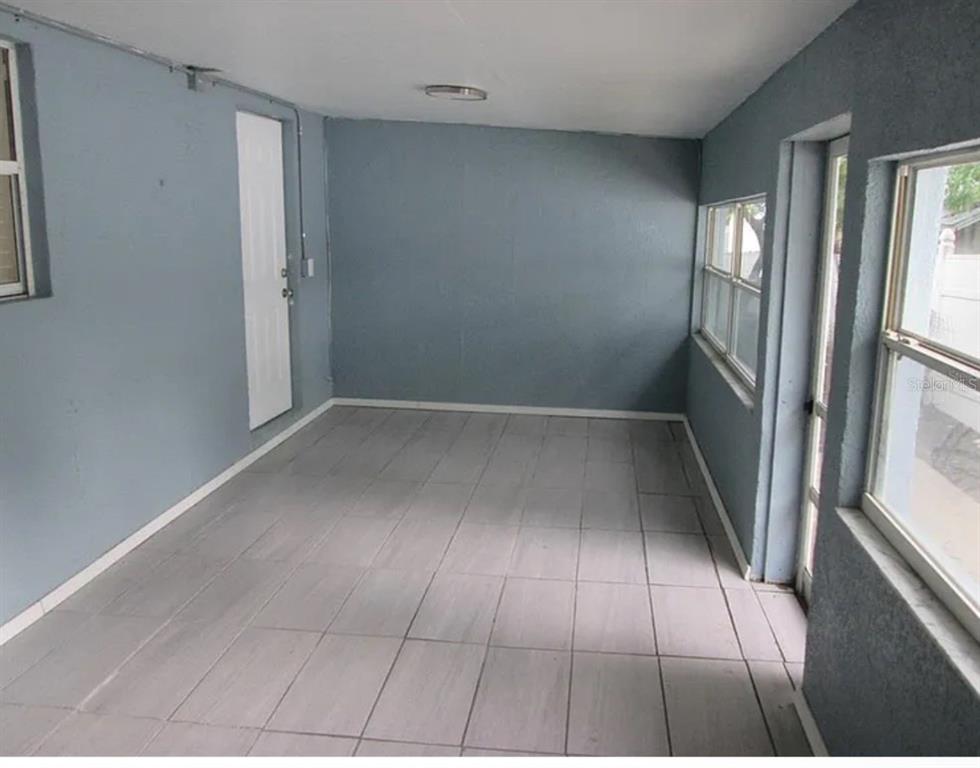 An enclosed porch with gray walls, tiled flooring, and multiple windows — 5901 28TH STREET N, ST PETERSBURG, FL