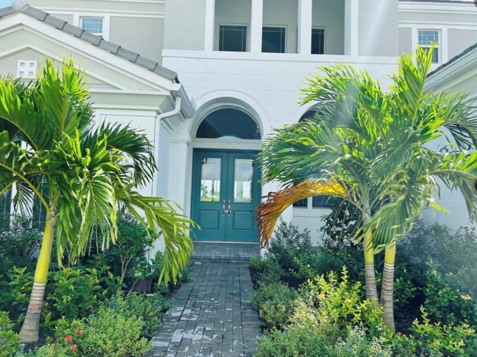 A teal double front door is centered at the entrance of a white house — 5199 Liberty Lane, Westlake FL 33470, WESTLAKE, FL