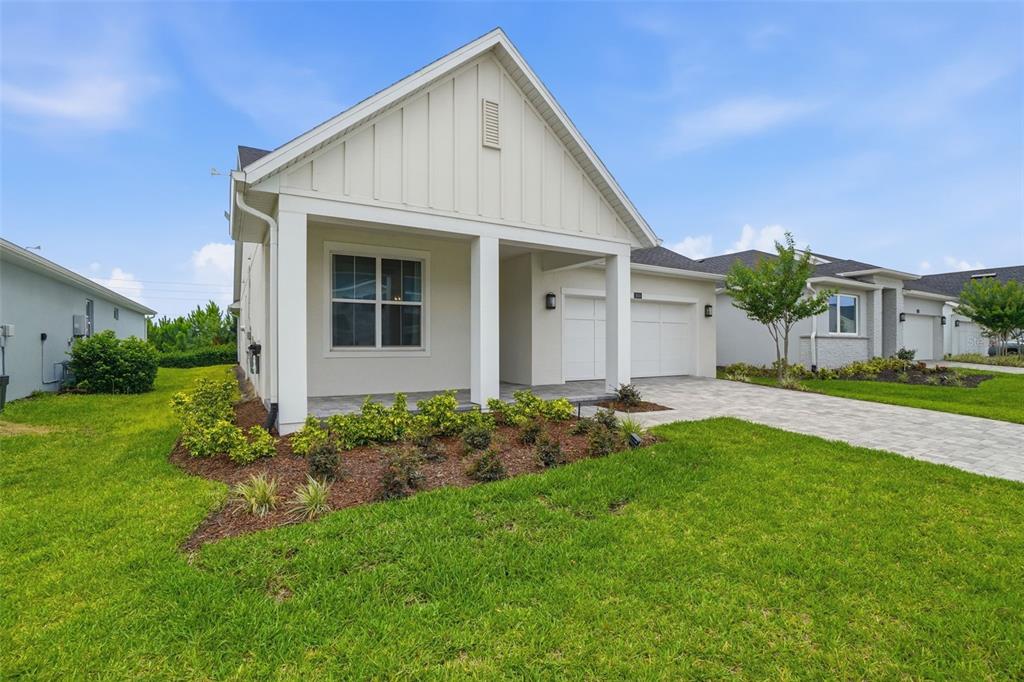 A single-story white house with a covered front porch and a paved driveway — 1658 PINECLIFF DRIVE, APOPKA, FL