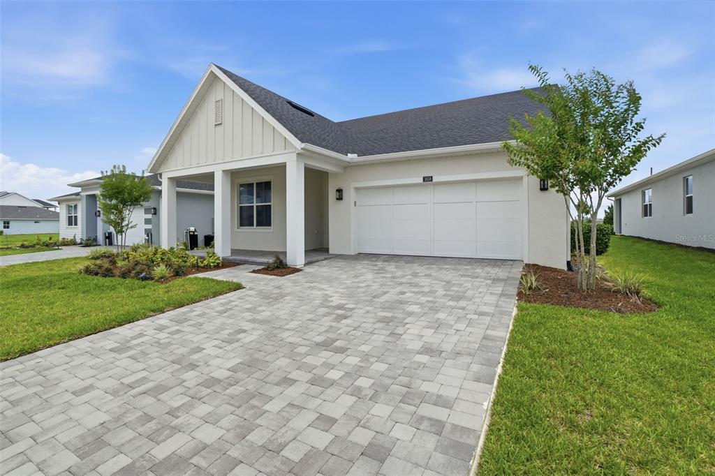 A single-story house with a white exterior, a two-car garage, and a paved driveway — 1658 PINECLIFF DRIVE, APOPKA, FL