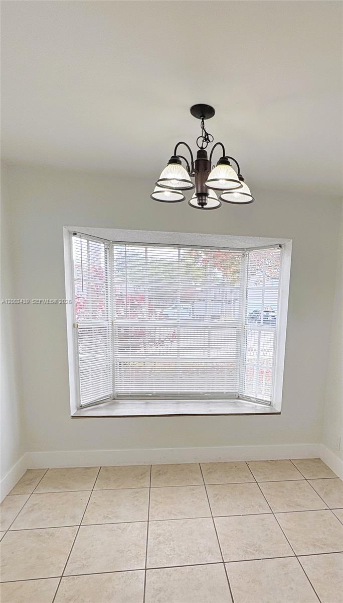 A dining area features a bay window with blinds, a chandelier, and tiled flooring — 3743 NW 122nd Ter, Sunrise FL 33323, SUNRISE, FL