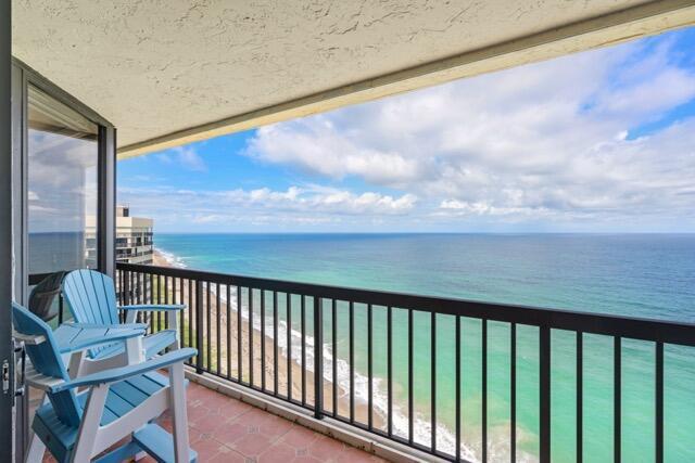 A balcony with two blue chairs overlooks the ocean and a sandy beach — 9550 S Ocean Drive # 4, Jensen Beach FL 34957, JENSEN BEACH, FL