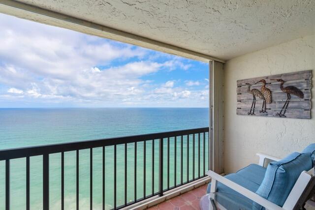 A balcony with a metal railing overlooks the ocean and features a blue cushioned chair — 9550 S Ocean Drive # 4, Jensen Beach FL 34957, JENSEN BEACH, FL