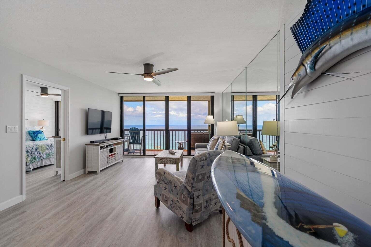 A living room with light wood floors, a ceiling fan, and a view of the ocean — 9550 S Ocean Drive # 4, Jensen Beach FL 34957, JENSEN BEACH, FL