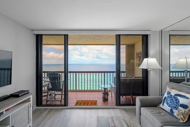 A living room with a balcony overlooking the ocean through large sliding glass doors — 9550 S Ocean Drive # 4, Jensen Beach FL 34957, JENSEN BEACH, FL