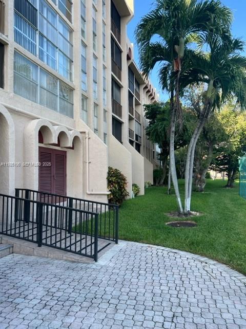 A multi-story building exterior features a black metal ramp leading to a red door — 2001 Atlantic Shores Blvd # 105, Hallandale Beach FL 33009, HALLANDALE BEACH, FL