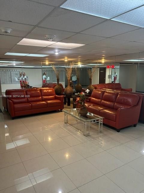 A room features two red leather sofas, a glass coffee table, and mirrored walls — 2001 Atlantic Shores Blvd # 105, Hallandale Beach FL 33009, HALLANDALE BEACH, FL