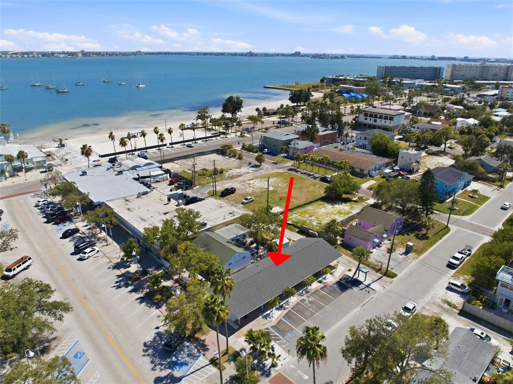 An aerial view shows a single-story commercial building with a parking lot near the coast — 3101 BEACH BOULEVARD S UNIT 1-5, GULFPORT, FL