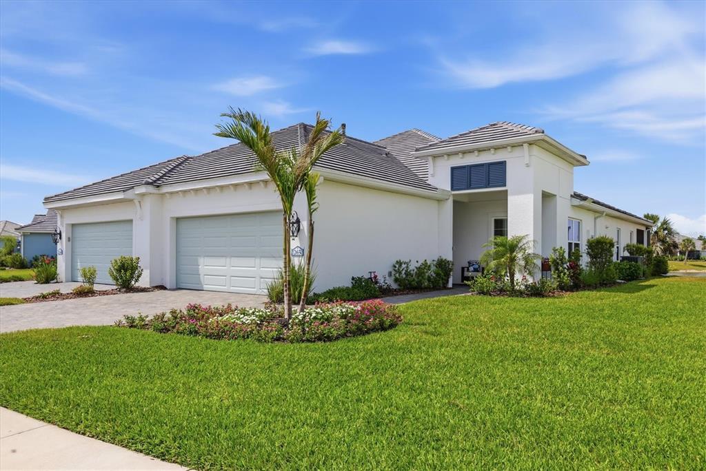 A single-story white house with a three-car garage and a landscaped front lawn — 12650 PALATKA DRIVE, VENICE, FL