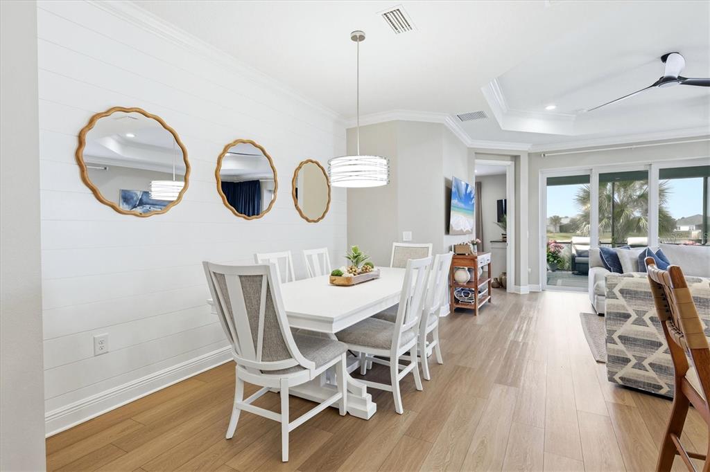 A dining area features a white table, chairs, shiplap wall, and three decorative mirrors — 12650 PALATKA DRIVE, VENICE, FL