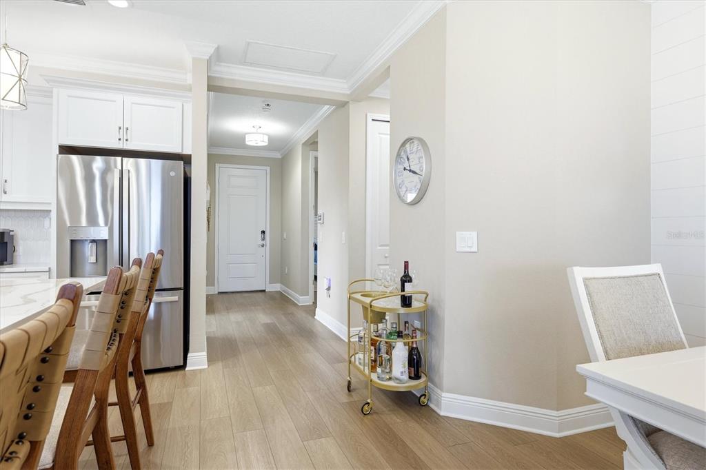 A kitchen and dining area with light wood floors, a stainless refrigerator, and a bar cart — 12650 PALATKA DRIVE, VENICE, FL