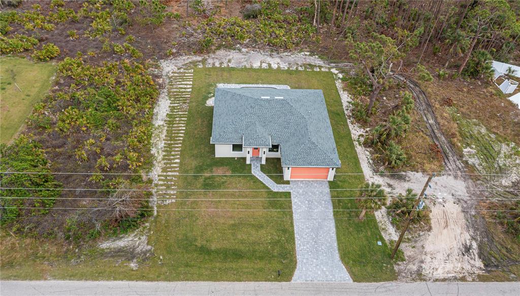 An aerial view shows a single-story house with a gray roof and orange garage door — 22528 MINERVA AVENUE, PORT CHARLOTTE, FL