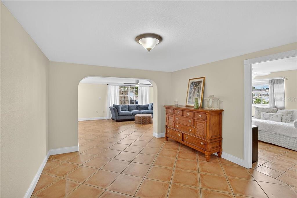 A dining area with tile floors leads through an arched opening to a living room — 4515 W NORTH STREET, TAMPA, FL