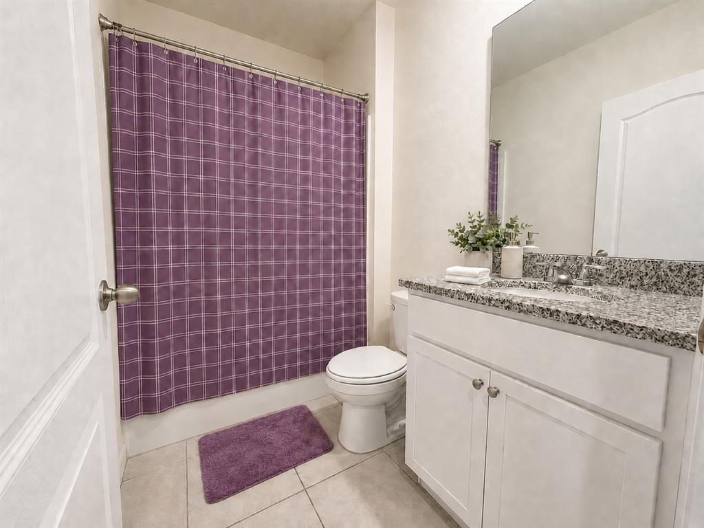 A bathroom features a purple plaid shower curtain, a white vanity, and granite countertops — 1117 GRIFFON AVENUE, LAKE ALFRED, FL
