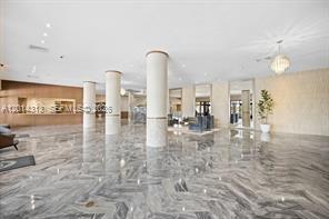 A spacious, modern lobby features polished marble floors, tall white columns, and recessed lighting — 5401 Collins Ave # 932, Miami Beach FL 33140, MIAMI BEACH, FL