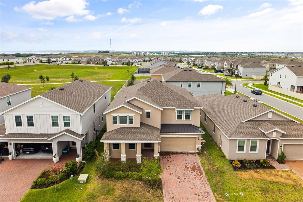 An aerial view shows three suburban houses with brick driveways and shingled roofs — 14452 CRESTAVISTA AVENUE, CLERMONT, FL