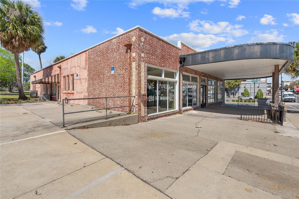 A brick commercial building with a covered drive-through area and a concrete parking lot — 304 S MAGNOLIA AVENUE, OCALA, FL
