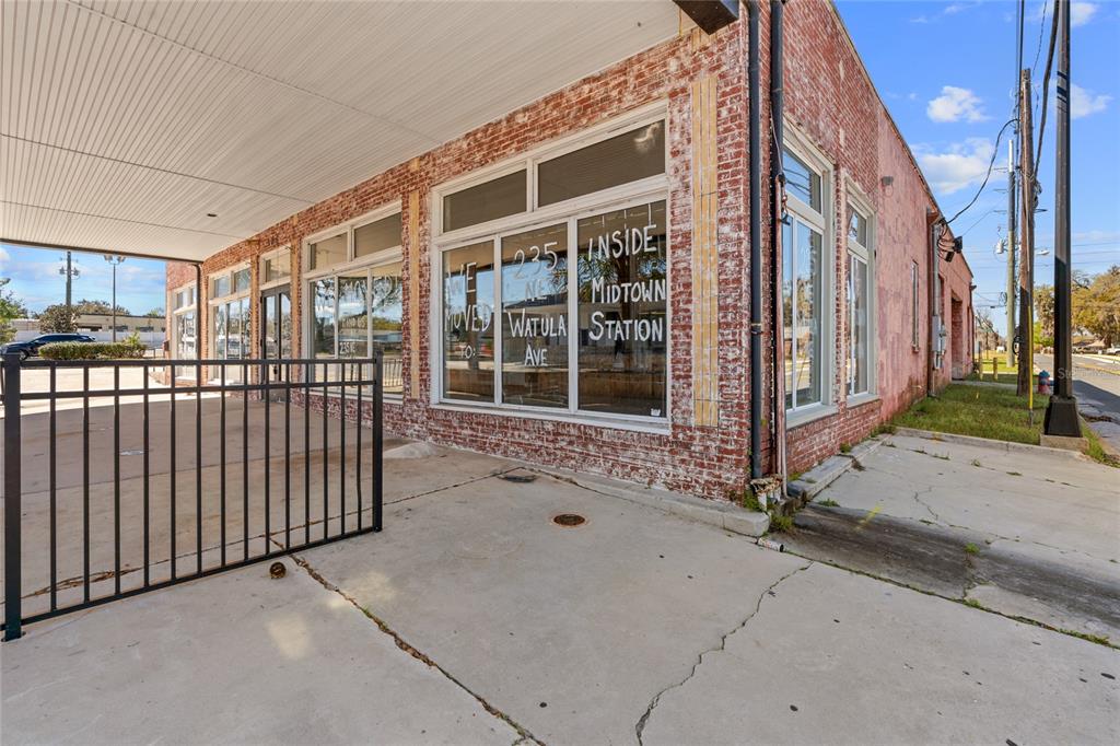 A brick commercial building exterior features large display windows and a covered concrete walkway — 304 S MAGNOLIA AVENUE, OCALA, FL