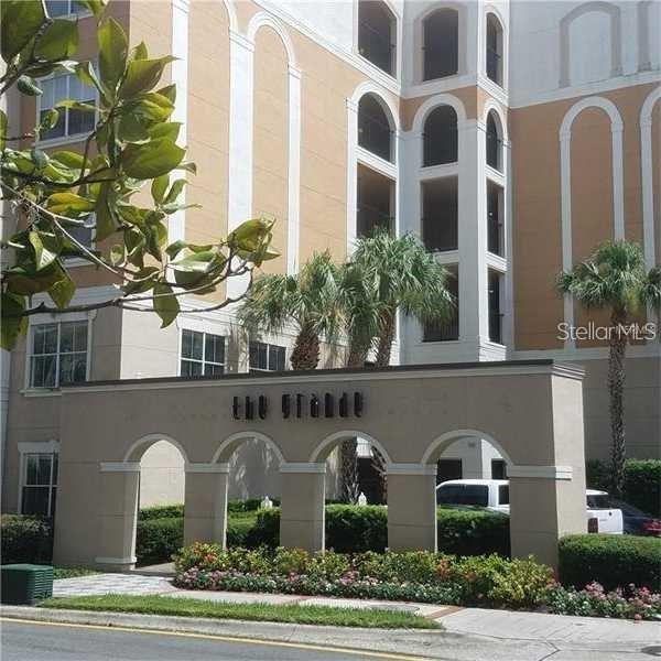 The exterior of a multi-story building features a decorative arched entryway sign labeled The Grande — 206 E SOUTH STREET UNIT 6034, ORLANDO, FL