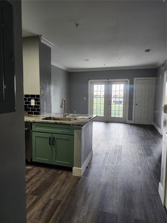 A kitchen with green cabinets and granite countertops opens into a living area with doors — 206 E SOUTH STREET UNIT 6034, ORLANDO, FL