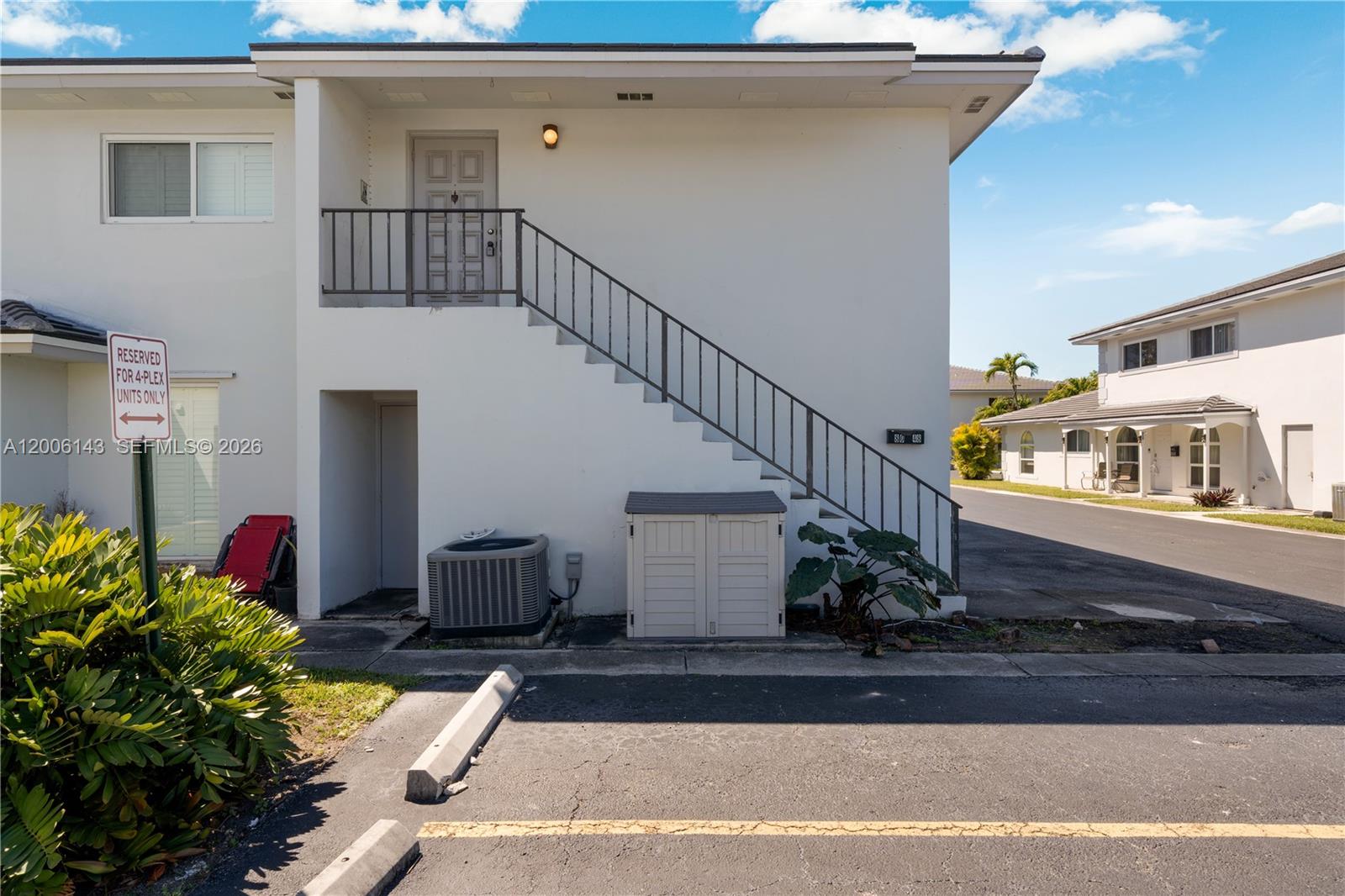 The exterior of a two-story apartment building features an outdoor staircase and a parking space — 8048 SW 80 AVE # 8048, Miami FL 33143, MIAMI, FL