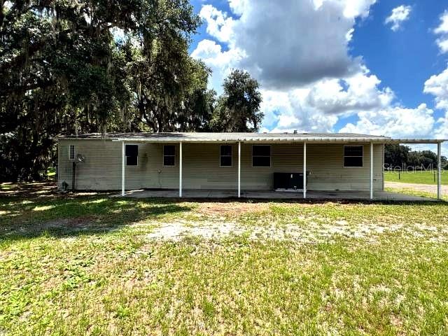 An interior view of a living area featuring damaged flooring and brown walls — 5411 PLESS ROAD, PLANT CITY, FL