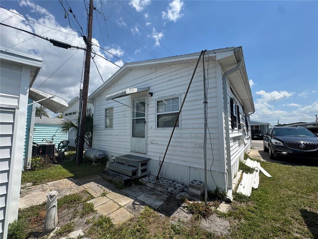 A white mobile home with a metal awning over the front door and exterior stairs — 2049 CHAMPION STREET, SARASOTA, FL