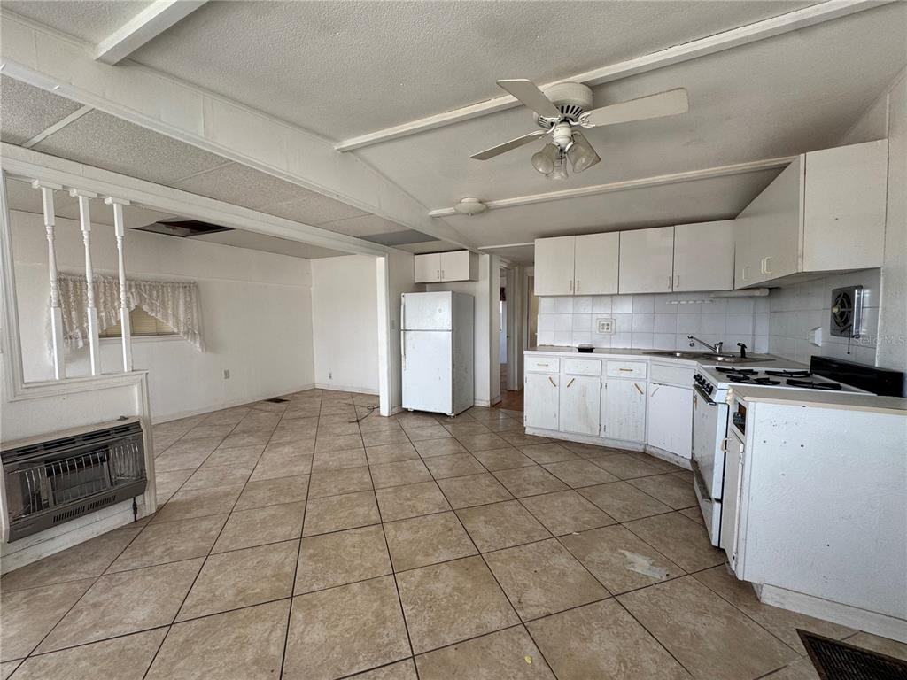 A kitchen and dining area with white cabinets, tile flooring, and a ceiling fan — 2049 CHAMPION STREET, SARASOTA, FL