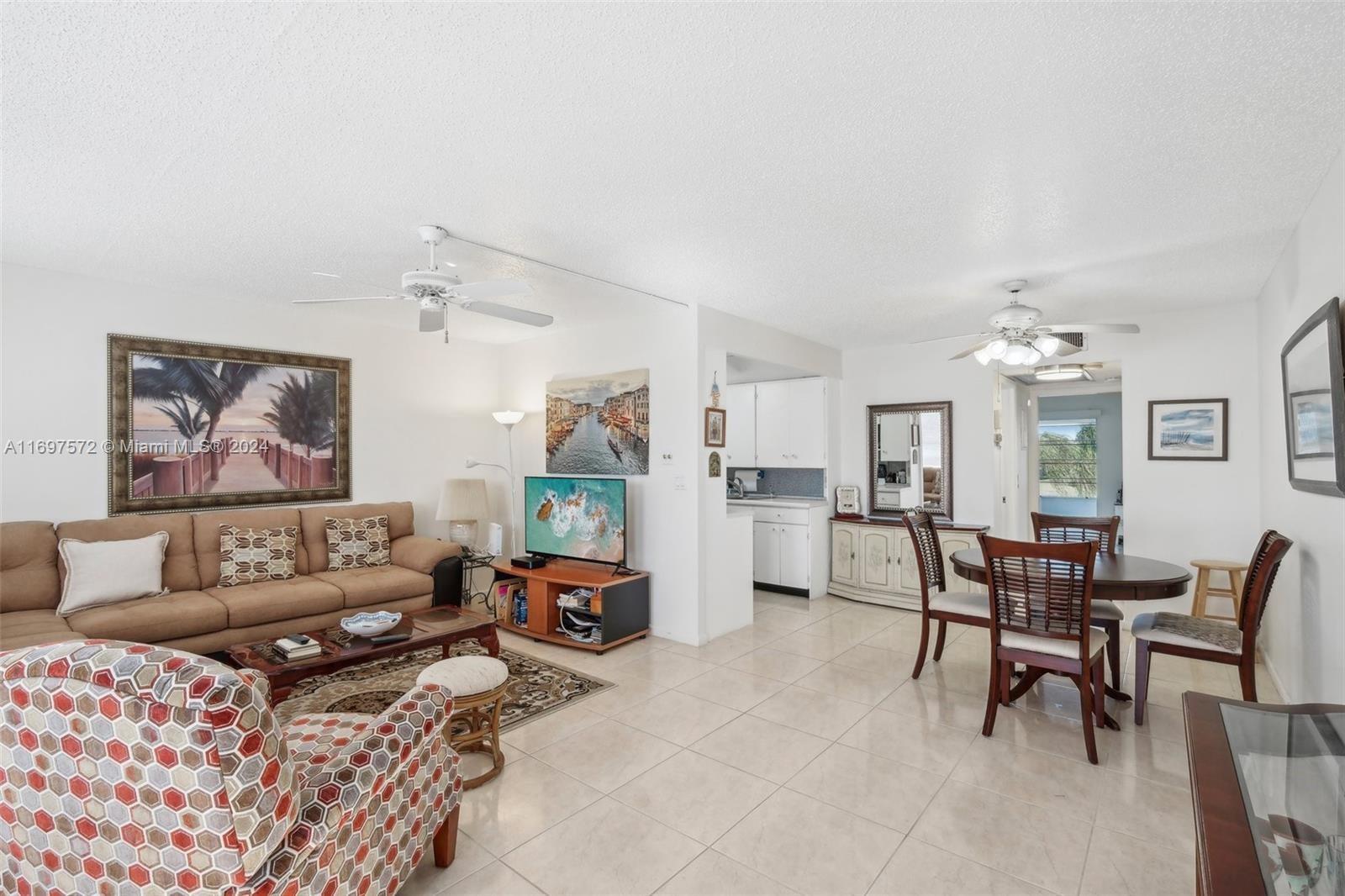 A living and dining area with tile floors, ceiling fans, and a kitchen in back — 3014 Oakridge A # 3014, Deerfield Beach FL 33442, DEERFIELD BEACH, FL