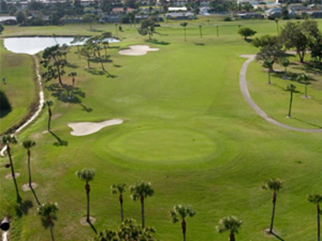 An aerial view of a golf course featuring a green, sand bunkers, and palm trees — 1155 BOUNDARY BOULEVARD, ROTONDA WEST, FL