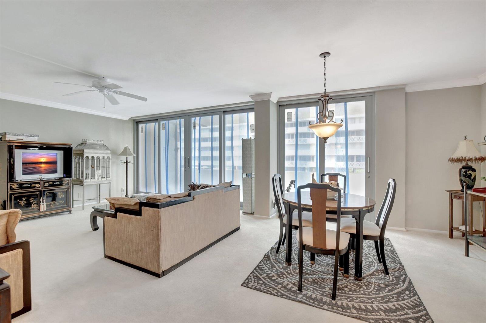 A living and dining area with a sofa, dining set, and large sliding glass doors — 1180 S Ocean Boulevard # 2e, Boca Raton FL 33432, BOCA RATON, FL