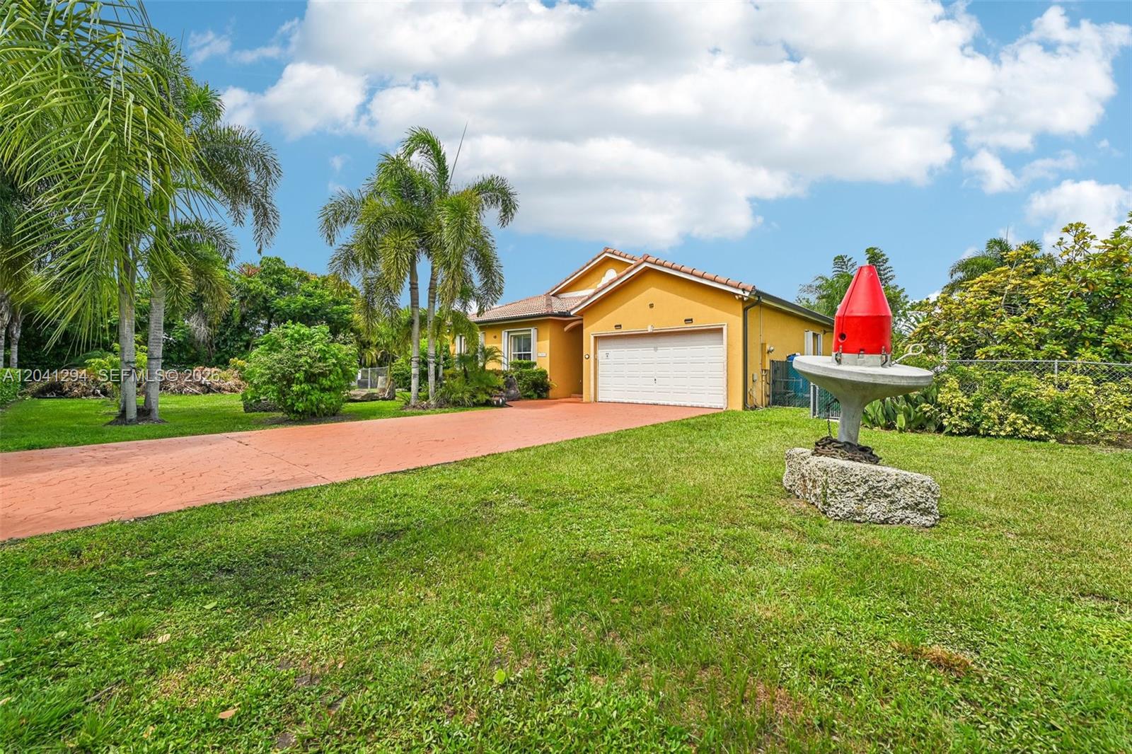 A yellow house with a two-car garage and a red navigational buoy in the yard — 21401 SW 187th Ave, Miami FL 33187, MIAMI, FL