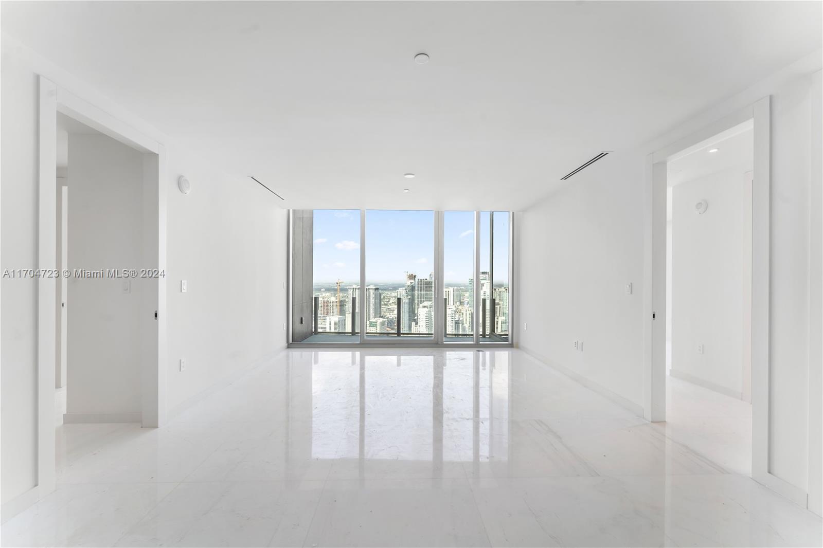 An empty, white-walled room features polished marble floors and floor-to-ceiling windows overlooking a city skyline — 300 Biscayne Blvd Way # 5209, Miami FL 33131, MIAMI, FL