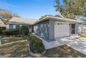 A single-story house with a gray exterior, a white garage door, and a front yard — 9020 SW 91ST TERRACE, OCALA, FL