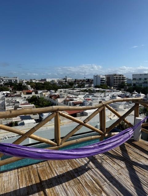 A purple hammock hangs on a wooden deck with a bamboo railing overlooking a city — 1405 25 th street # 1405, MX, MX